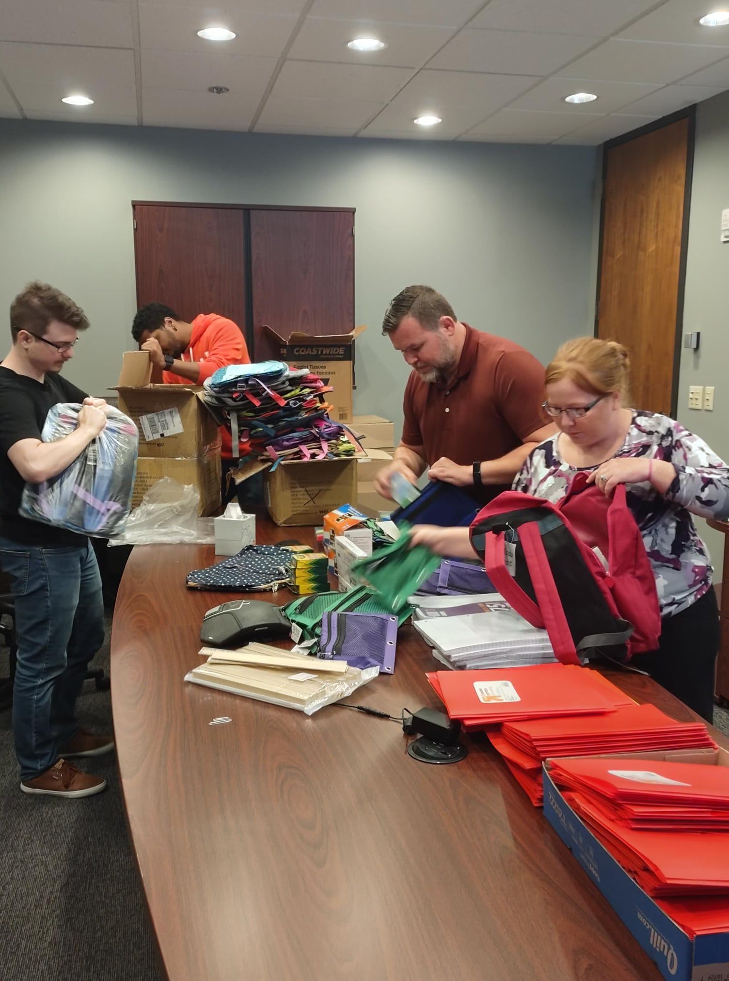 Team packing backpacks with school supplies for Operation Backpack 2021