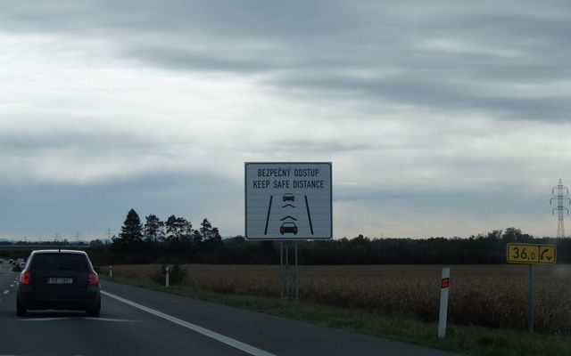 Road sign showing distance between cars