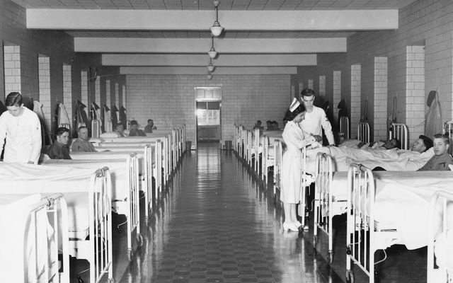 Nurses attend to patients in a hospital ward.