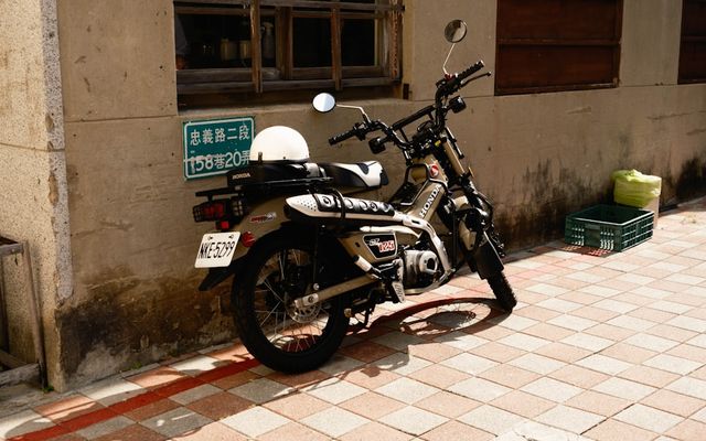 A parked motorcycle with a white helmet on the seat.