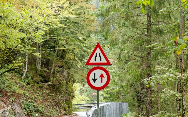 Road signs indicating narrow road and two-way traffic ahead