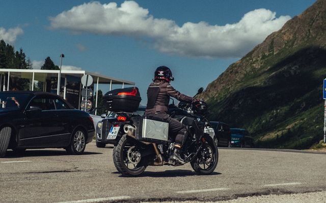 Motorcyclist riding on a mountain road with cars
