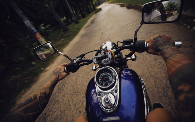 man in black framed eyeglasses riding blue and black motorcycle during daytime