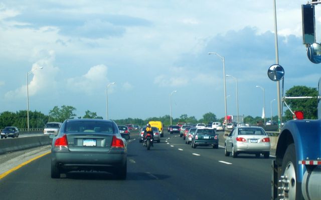 a motorcycle and cars driving down the road