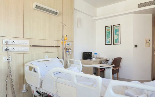 a hospital room with a bed and a desk