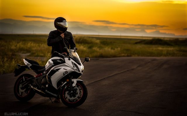 man in black jacket riding white sports bike on road during daytime