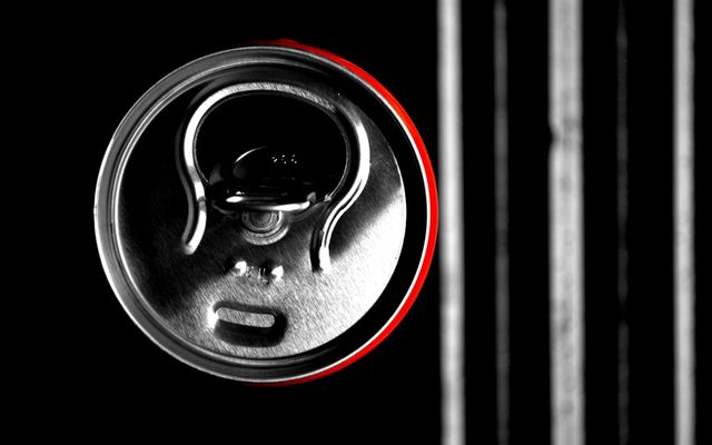 A black and white photo of a can of soda