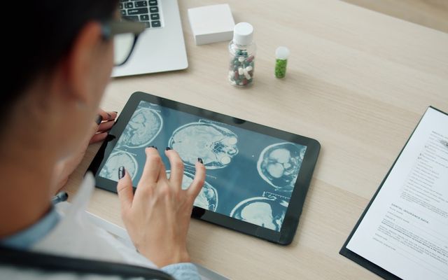 Doctor examining mri scans on a tablet screen