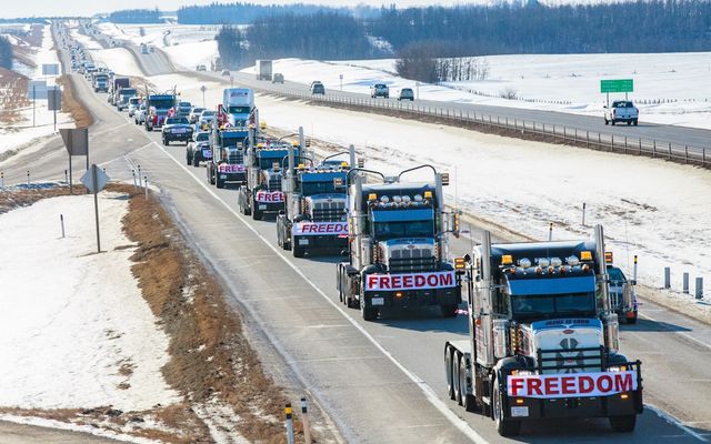 a long line of trucks driving down a highway