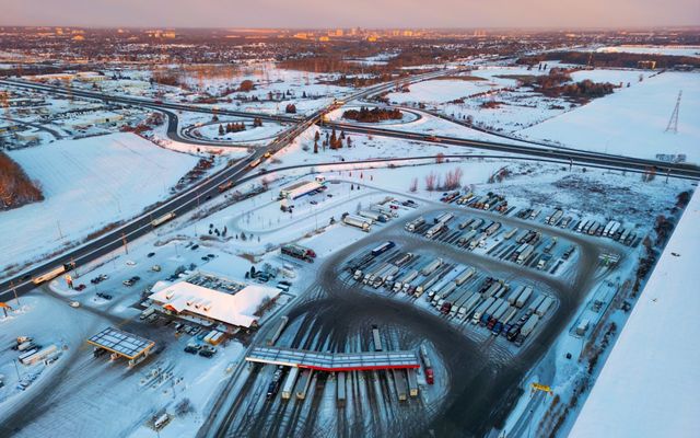 Aerial view of a snowy truck stop and highway interchange.