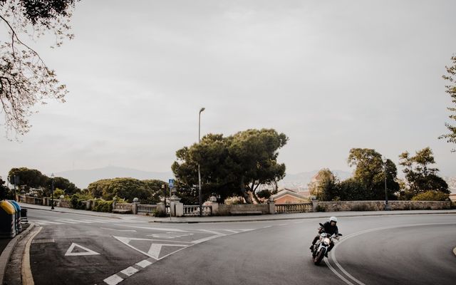 a man riding a motorcycle down a curvy street