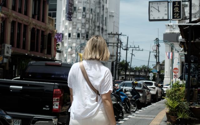 Woman walks down a busy city street.