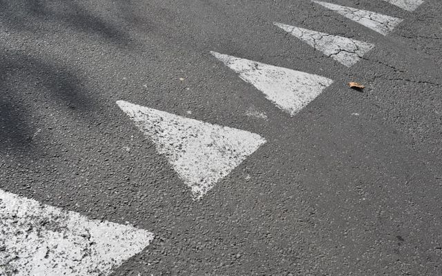 White triangles painted on asphalt road surface.