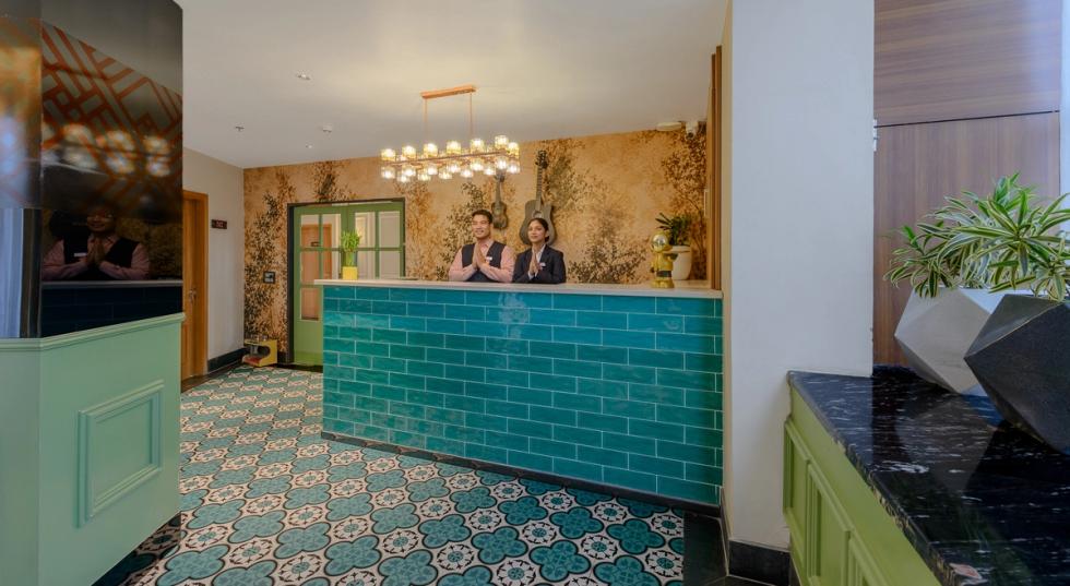 Hotel reception area in Rishikesh with front desk, patterned flooring and contemporary interior design.