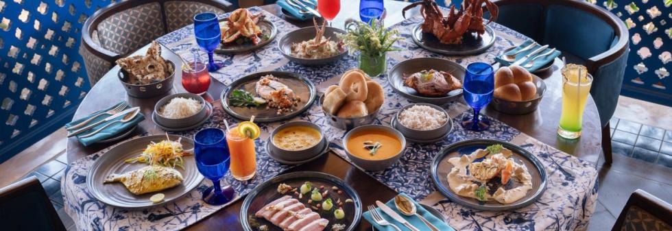 Large Indian breakfast table set with breads curries and drinks