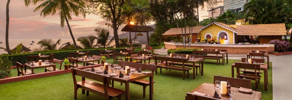 Outdoor seating area with wooden table and palm trees