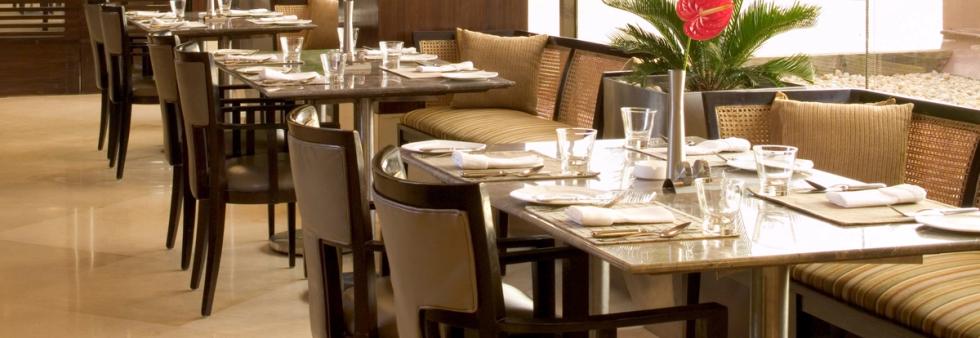 Indoor dining area with large windows overlooking the sea