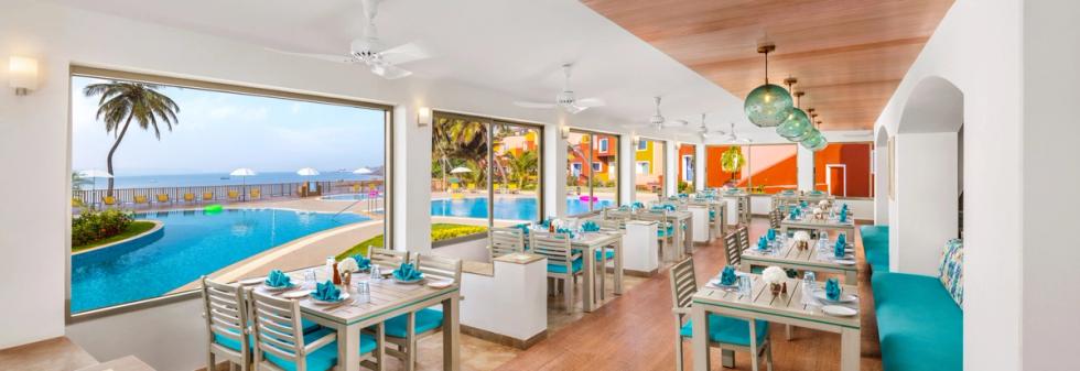 Restaurant interior with turquoise chairs and large poolside windows