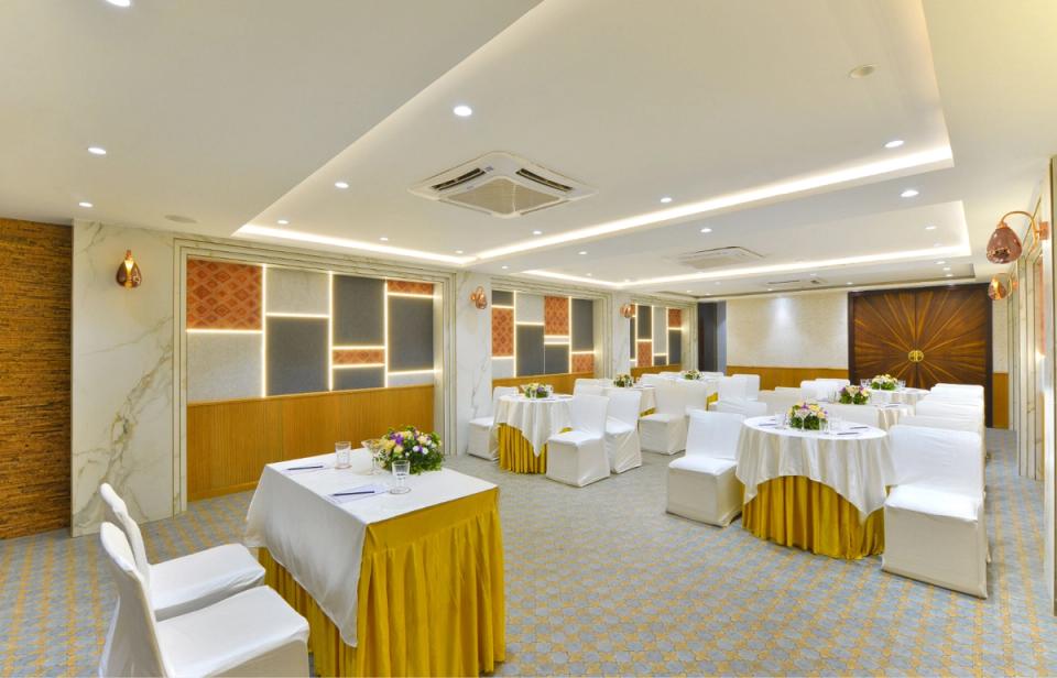 Banquet hall and meeting room setup with round tables at Ginger Indore, Nipania.