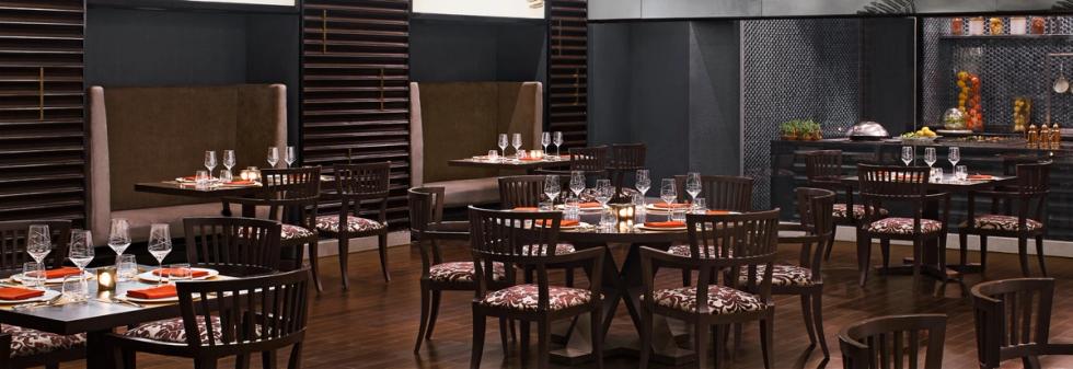 Fine dining restaurant featuring wooden floors, booth seating, and table settings