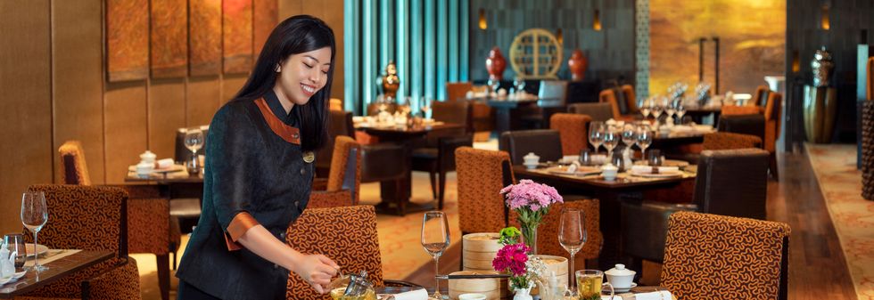 Luxury restaurant service with staff pouring tea at an elegant table
