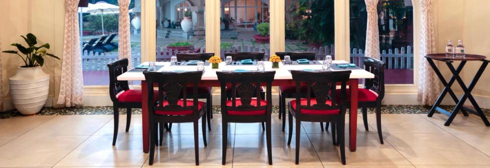 Indoor dining table with red chairs and garden view