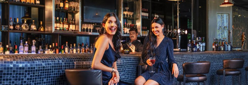 Guests enjoying drinks in luxury lounge bar behind the counter