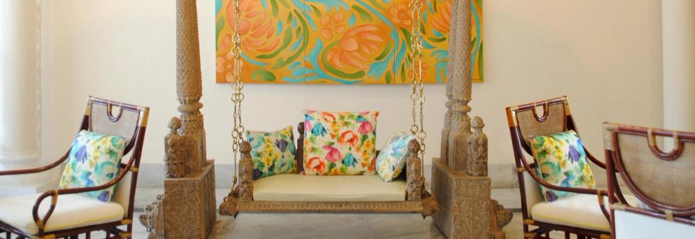 Indoor lounge with wooden swing and floral cushioned chairs