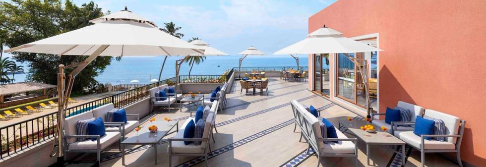 Outdoor terrace with sofas, umbrellas, and ocean view