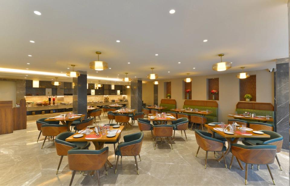 Qmin Indore Nipania restaurant dining area with modern tables and chairs.
