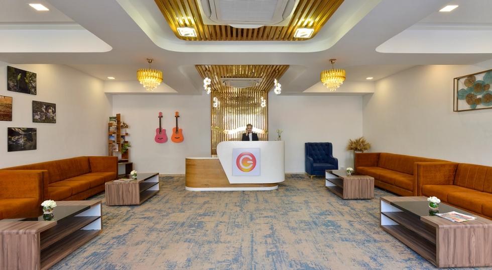 Modern lobby at Ginger Kheda, Dholka–Kheda Highway with reception desk, sofas, and warm lighting.
