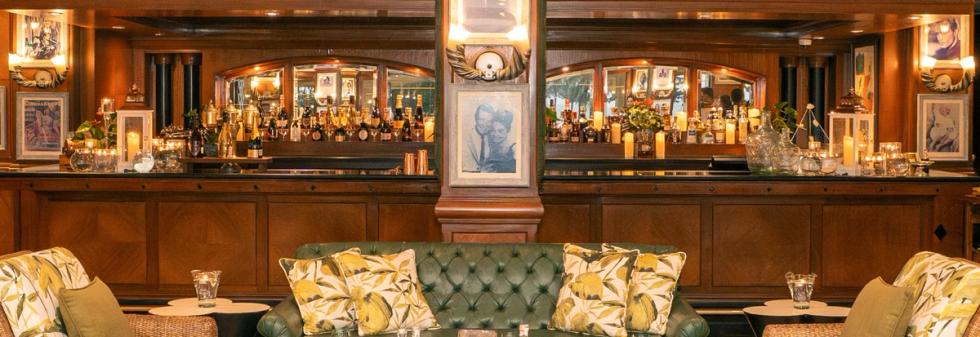 Elegant Wooden Bar Lounge with Vintage Portraits and Red Cushioned Chairs