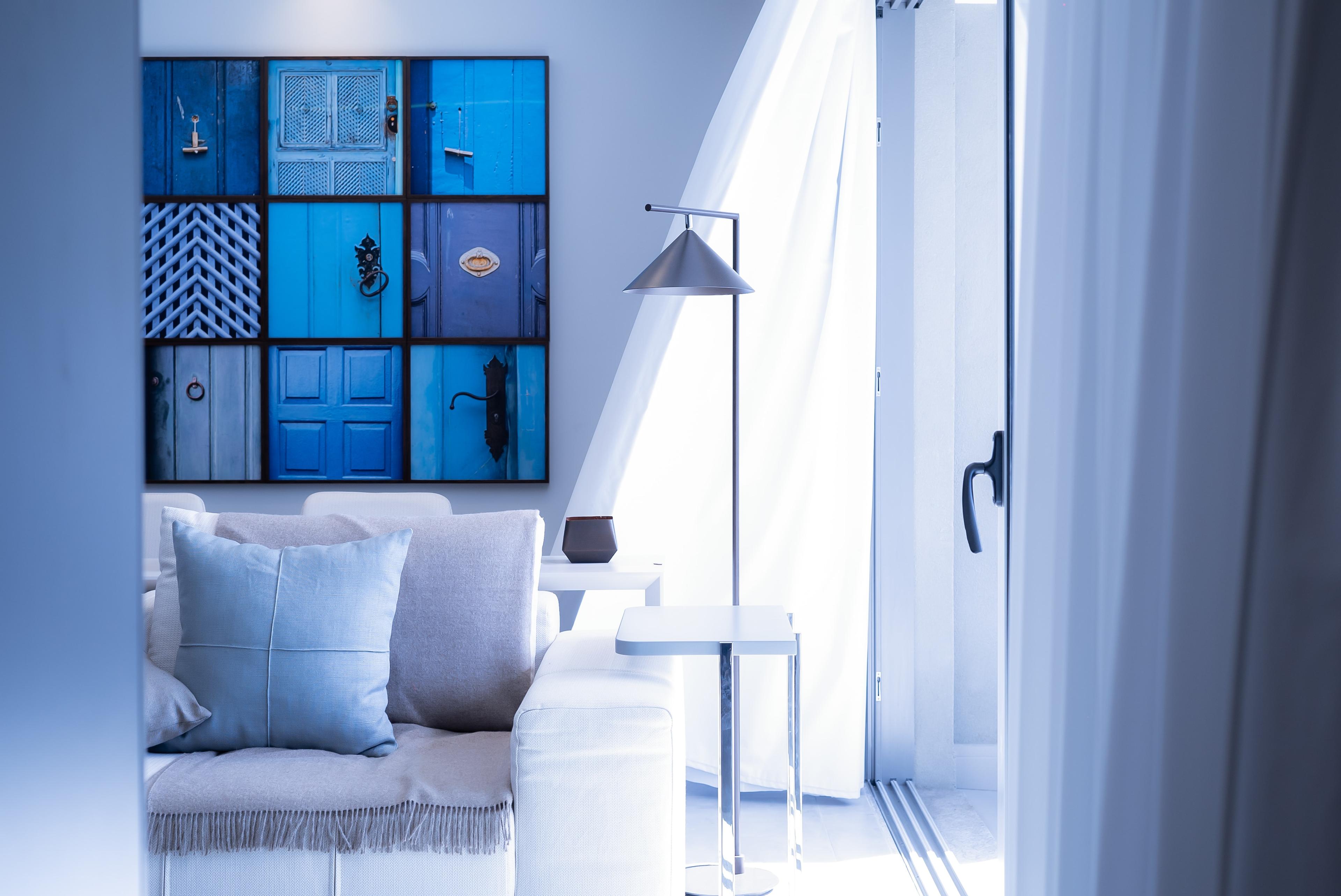 Using blue as a accent with couch and lighting and art showcased in blue hues