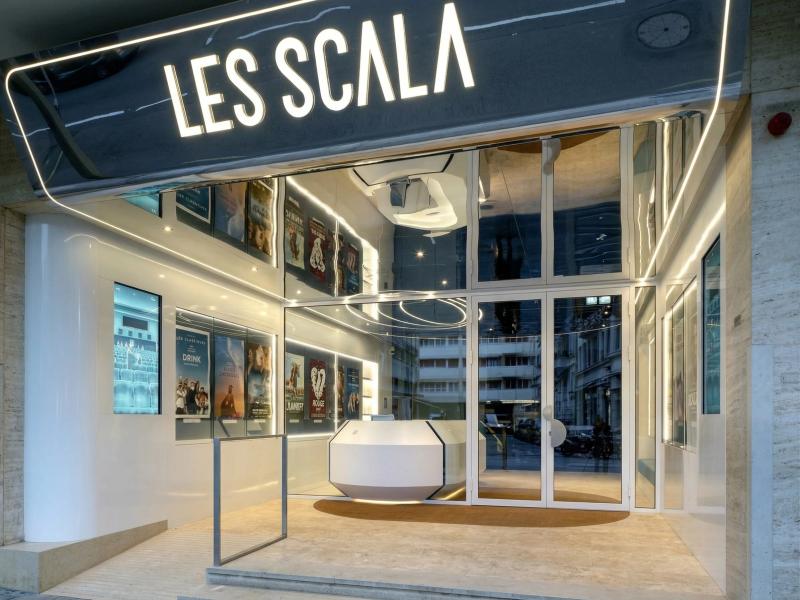 Strefa wejściowa kina Les Scala z lustrzanymi elementami elewacji