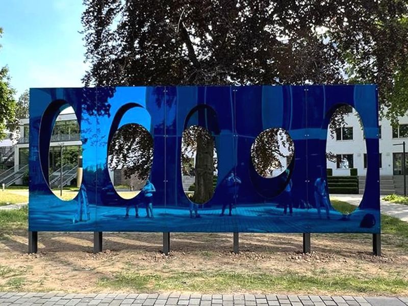 Niebieska rzeźba Imagine autorstwa Rainer Splitt z owalnymi otworami w parku