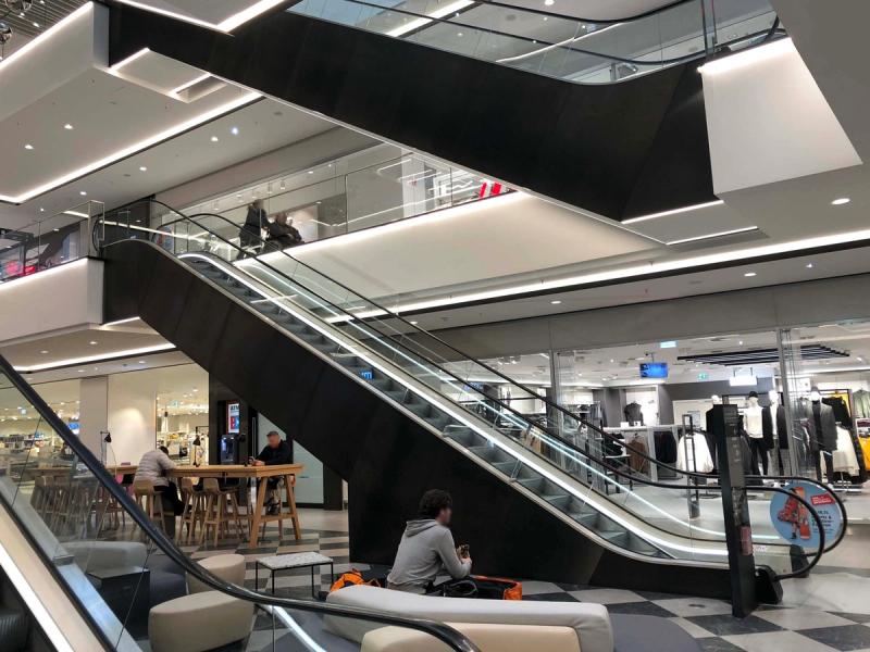 Nowoczesne centrum handlowe w Monachium z ruchomymi schodami i jasną strefą wypoczynkową