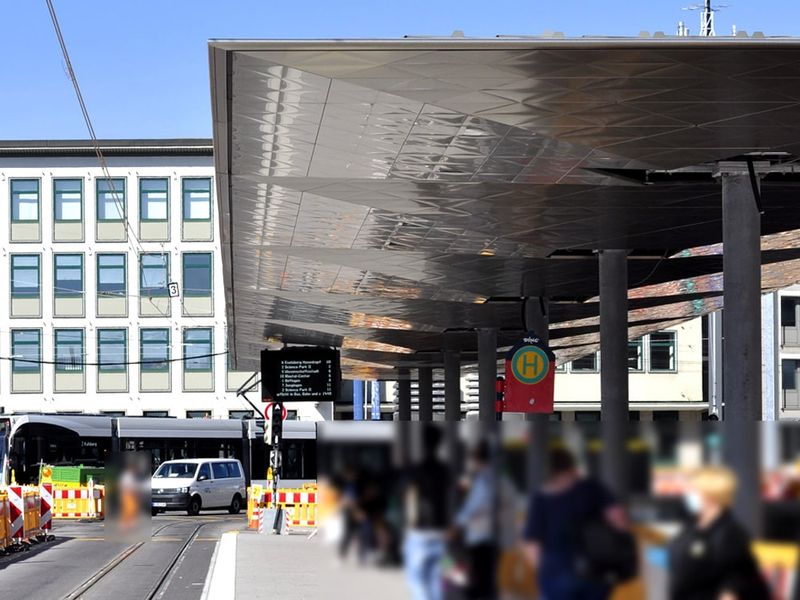 Peron na dworcu autobusowym z futurystycznym zadaszeniem i oczekującymi pasażerami