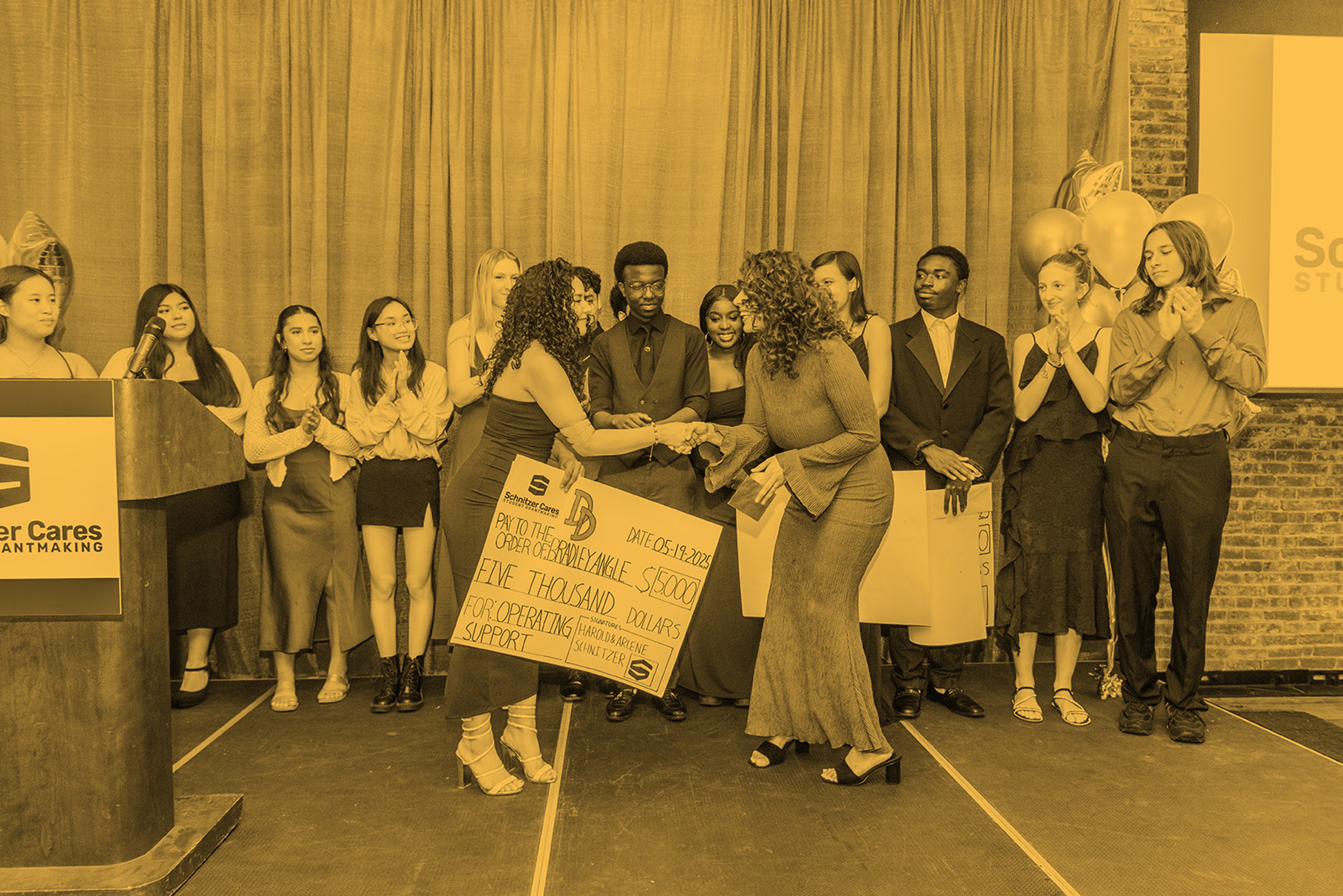 Grant recipient receiving a check on stage #0