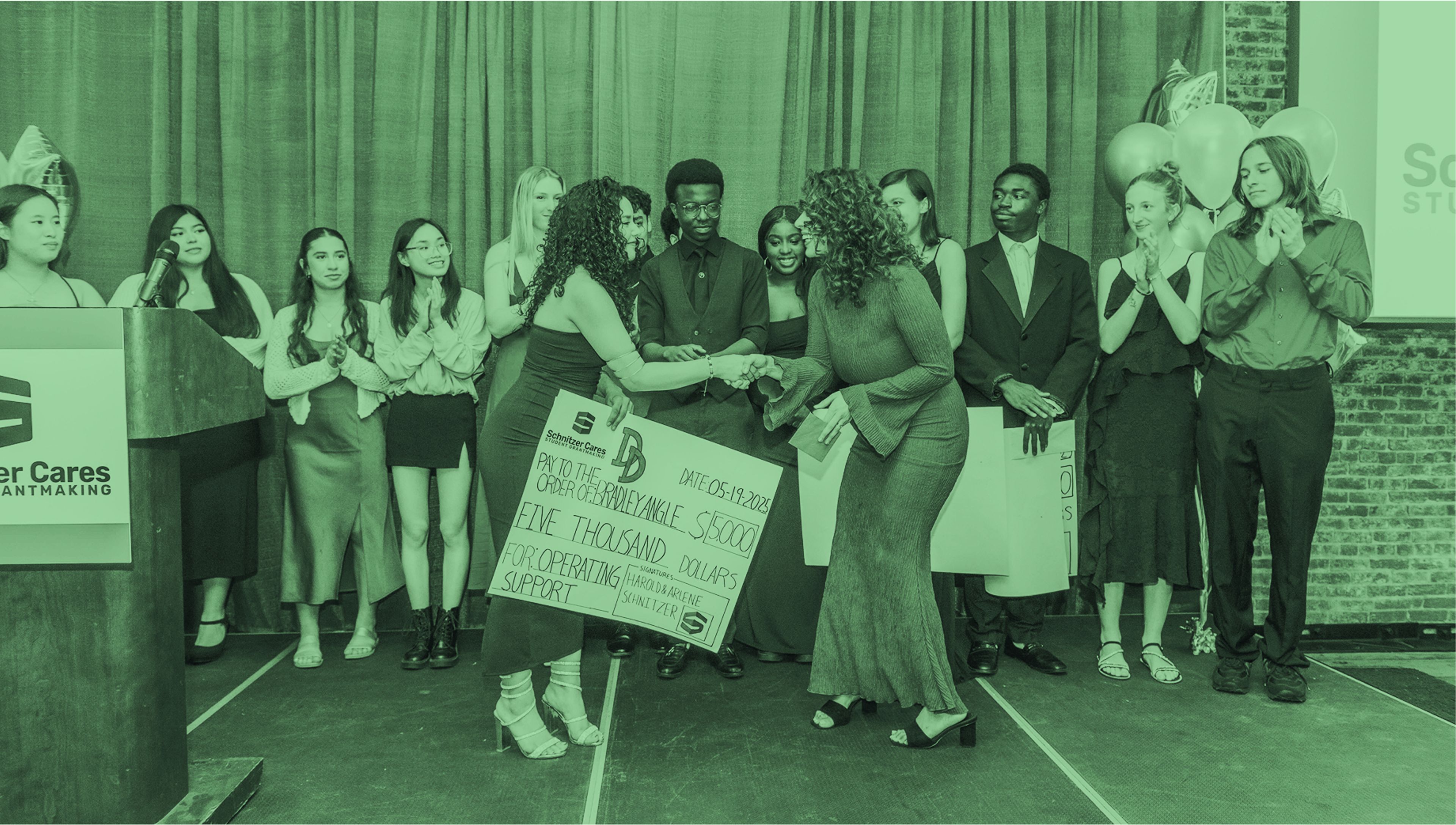 Grant recipient receiving a check on stage #0