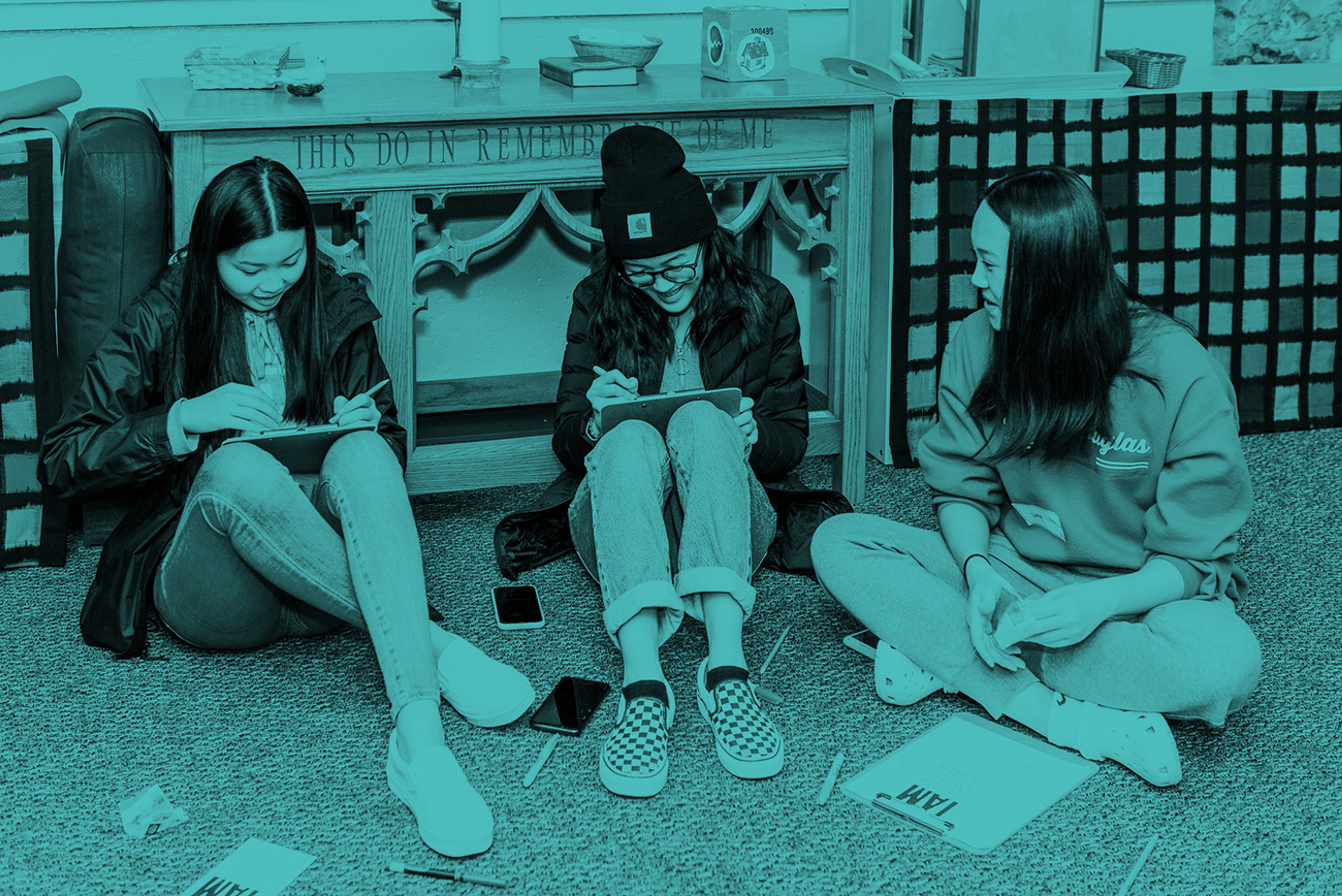 Students sitting on the ground writing on clipboards #0