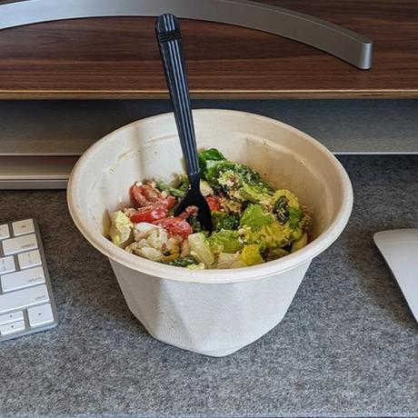 Cobb salad in a compostable container at an office desk.