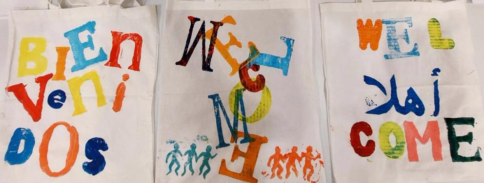 Image of screen printed tote bags with the words 'welcome' on them