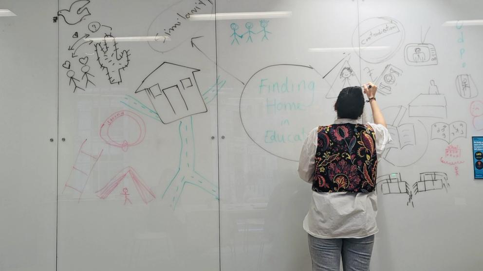 Image of female student drawing on a white board