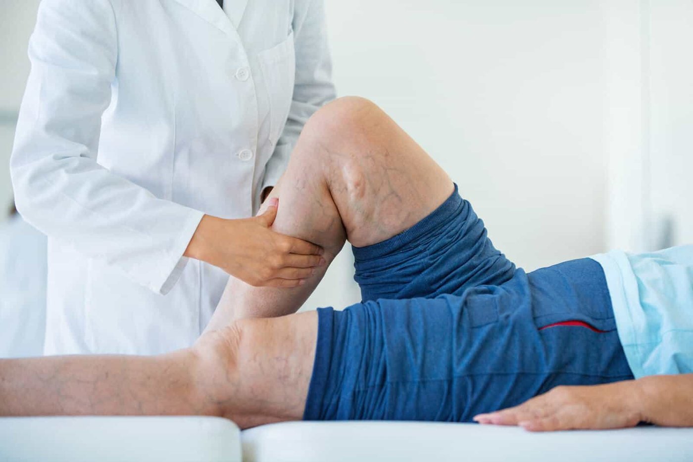 Médico angiólogo evalúa la pierna de un paciente durante la consulta
