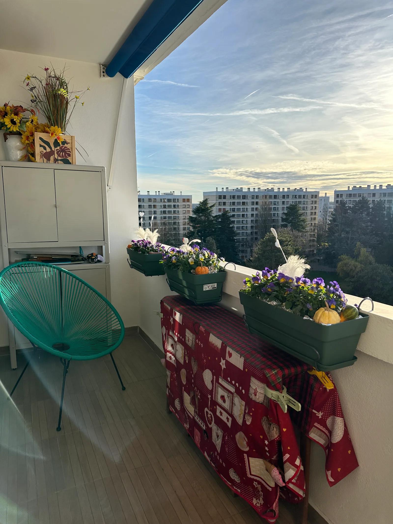 Loggia aménagée avec fauteuil et jardinières, vue sur les immeubles voisins — Meudon-la-Forêt.