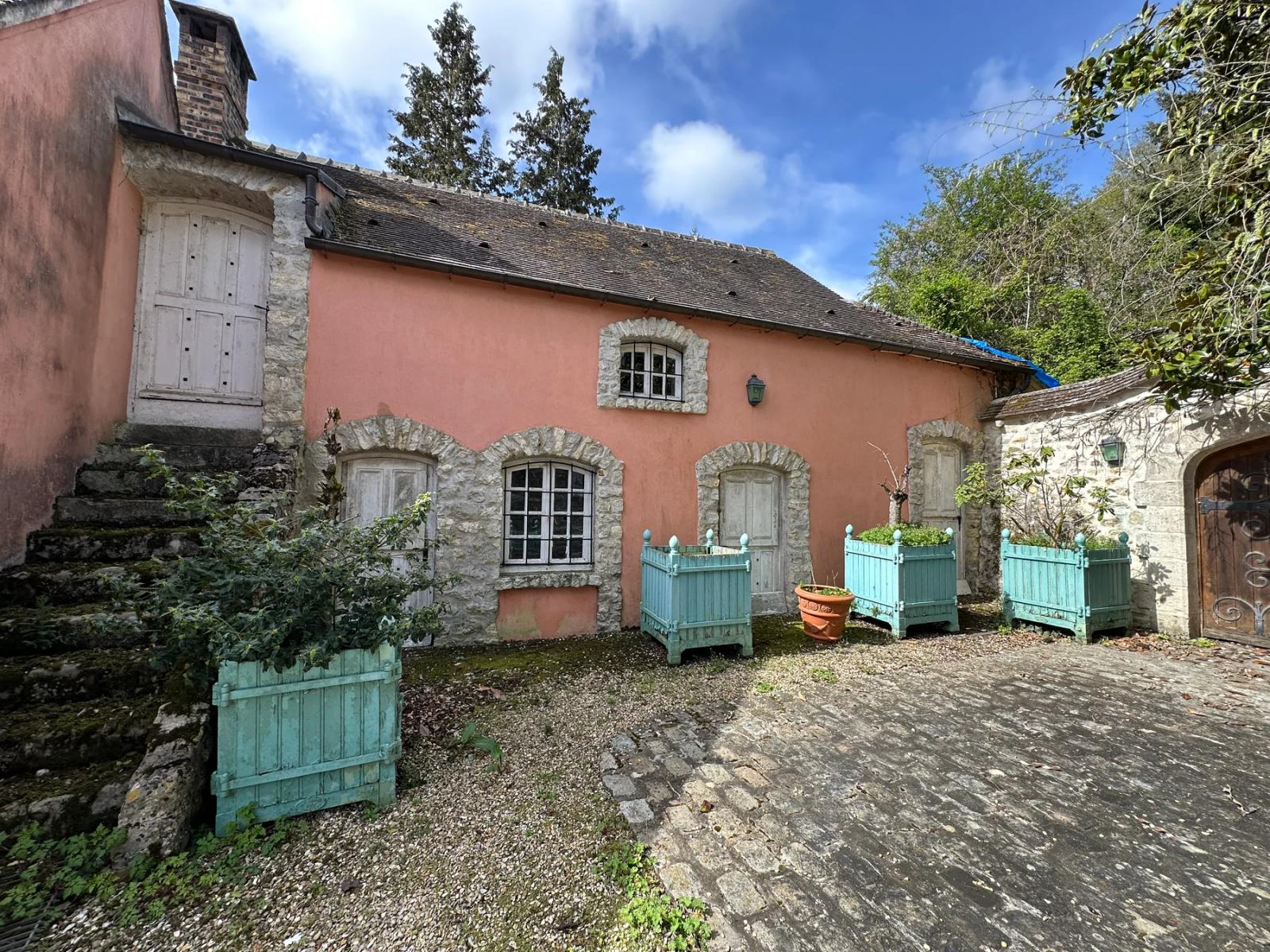 Dépendance à façade rose avec volets verts donnant sur la cour — Villeconin.