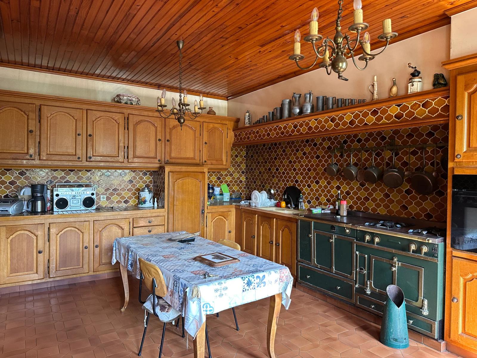 Cuisine avec meubles en bois, grande cuisinière et table centrale — Villeconin.
