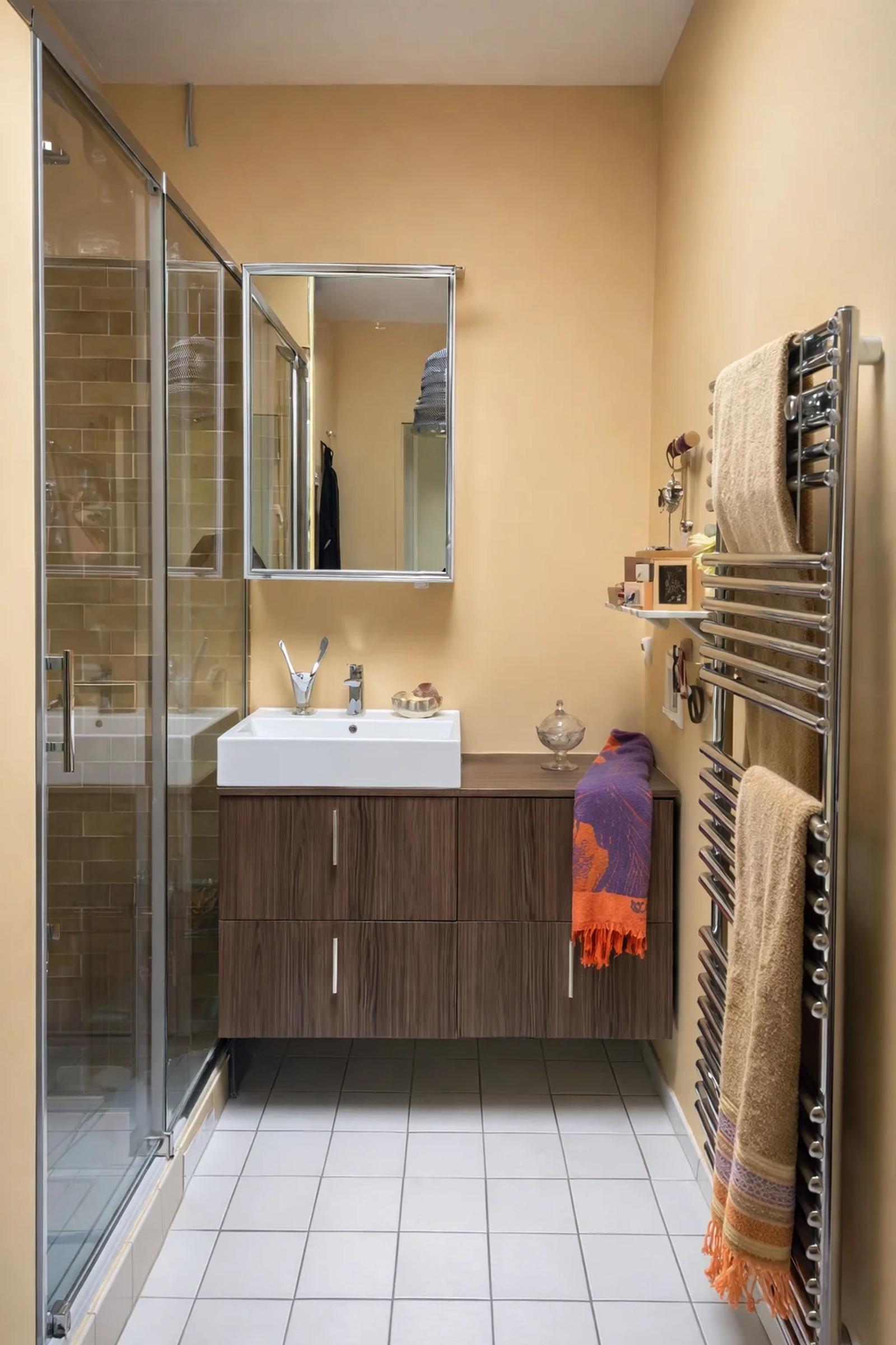Salle d’eau avec douche vitrée, vasque et sèche-serviettes — Croissy-sur-Seine.