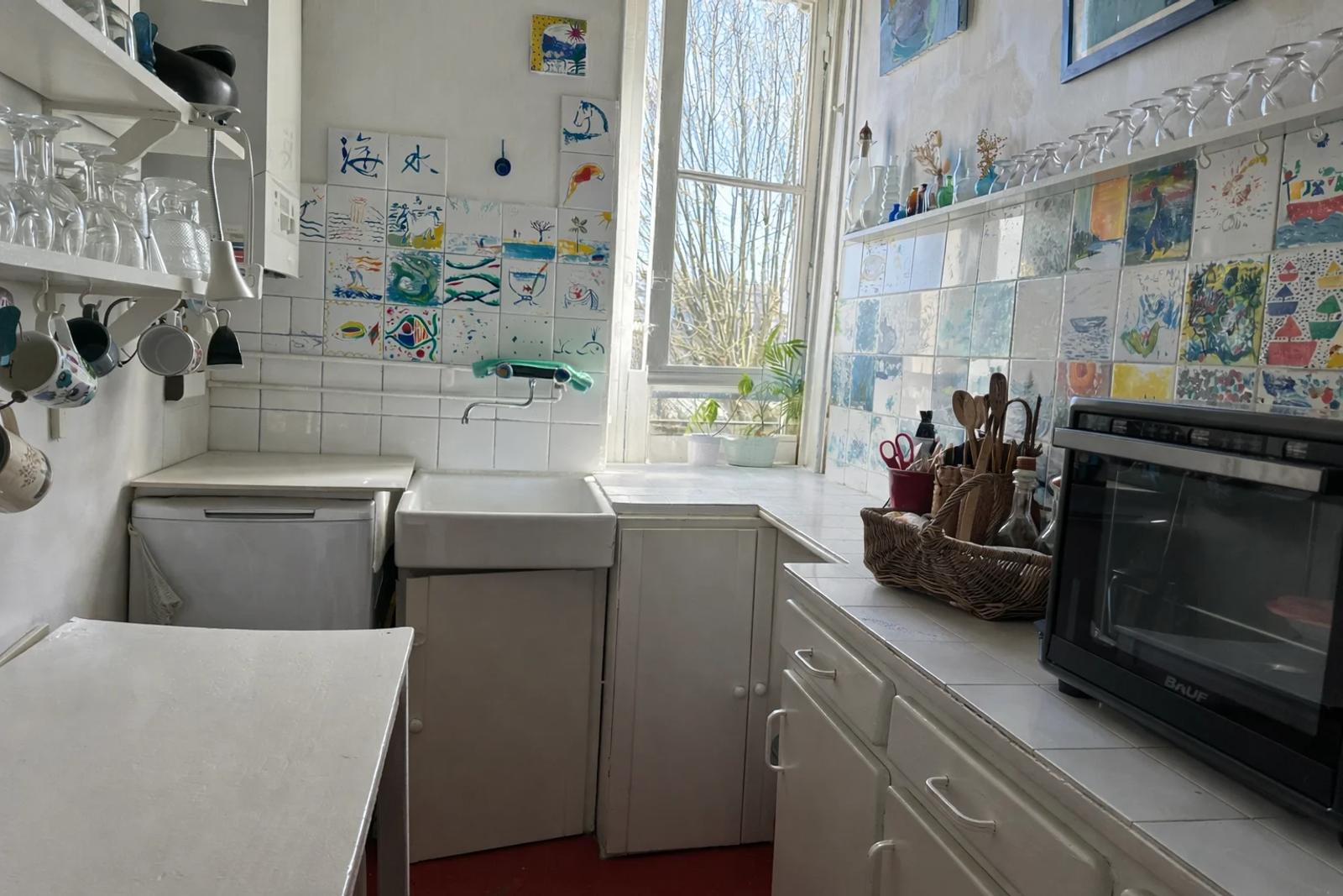 Cuisine blanche avec plan de travail sous la fenêtre — Paris 14e.