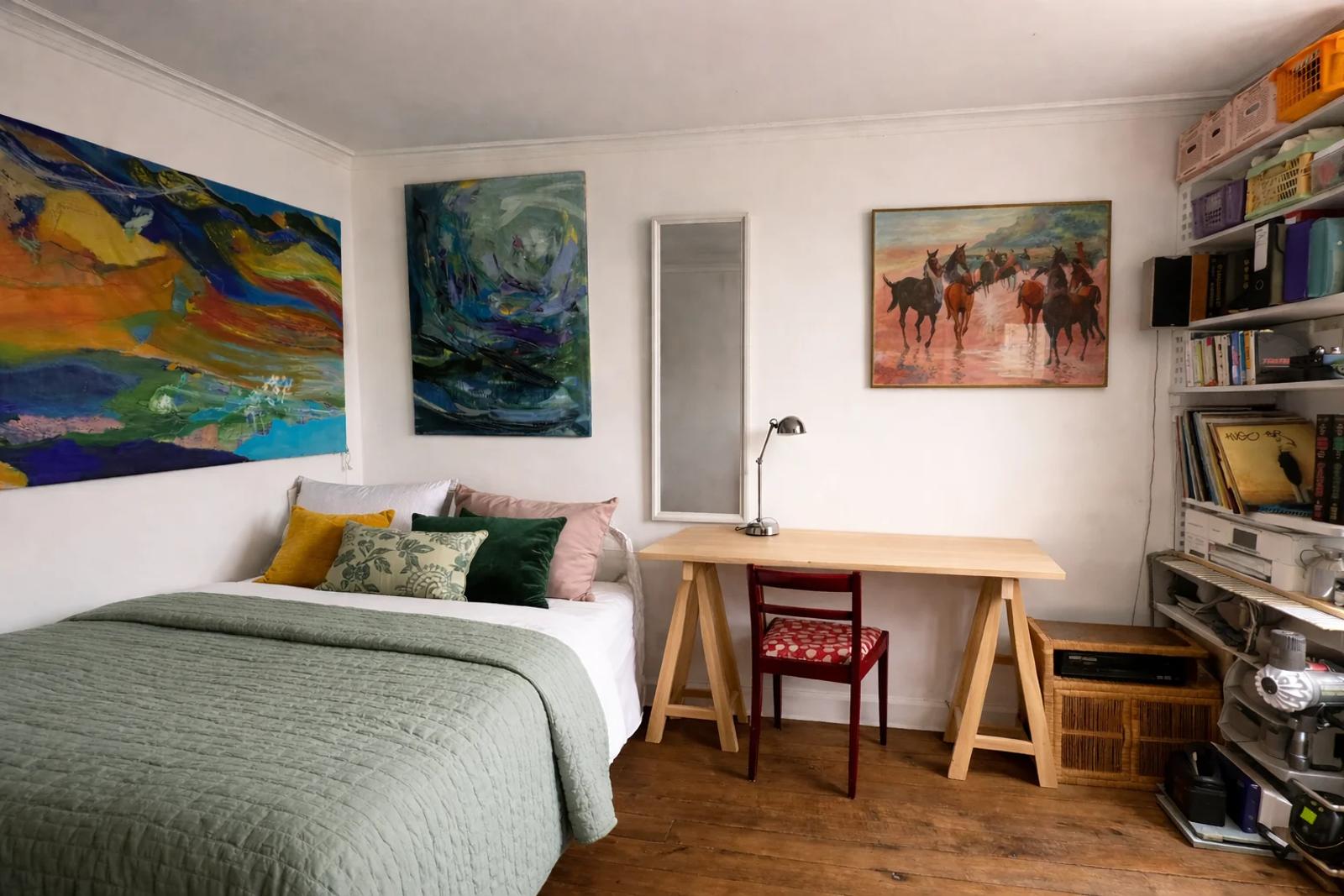 Chambre avec lit double, bureau et bibliothèque — Paris 14e.